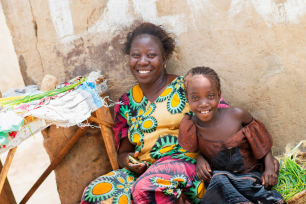 dakar, senegal, africa: unidentified woman selling fruits and vegetables in the street with her daughter, sandaga market - africa south africa child african culture imagens e fotografias de stock