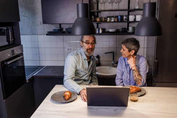 istock Mature couple using laptop during breakfast at home 1469672150