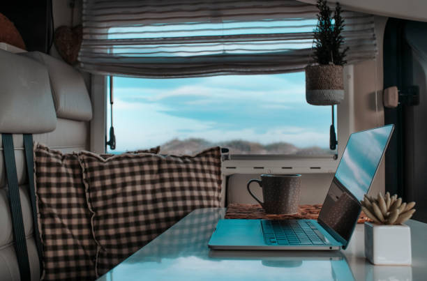 istock Digital nomad vanlife concept modern business people. One computer laptop on the table inside a camper van with outside nature view. Alternative office and nomadic life. Technology and work off grid 1469672967