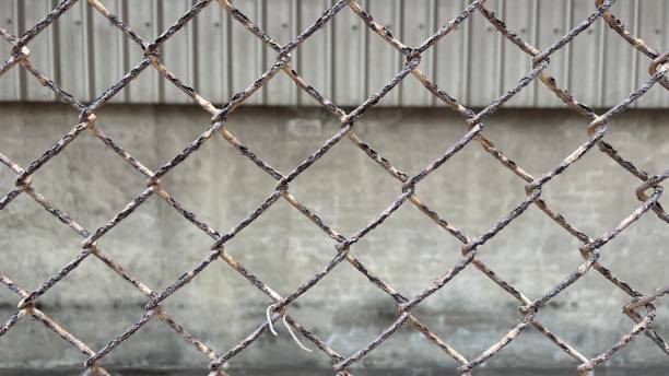 istock Abandoned factory is surrounded by broken and rusty cross iron netting 1469673668