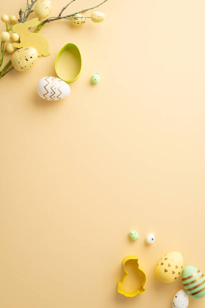 istock Easter decorations concept. Top view vertical photo of colorful easter eggs baking molds and easter bouquet on isolated beige background with copyspace 1469675365