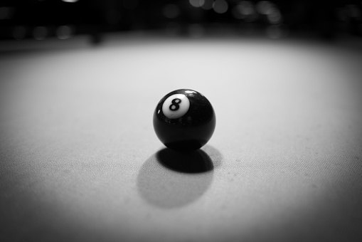 the black billiard ball is on the billiard table