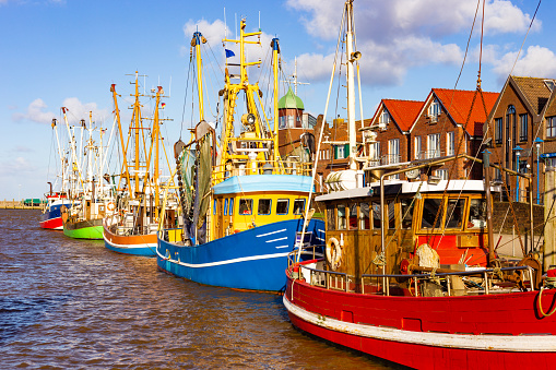 The fishing village Neuharlingersiel in Germany on the coastline with ducked boats
