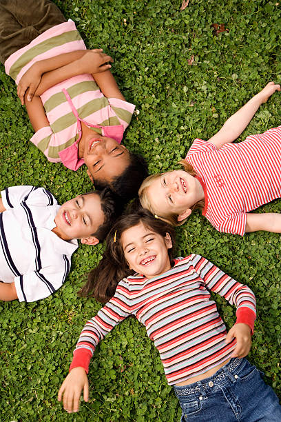 istock 4 children lying on green clover with heads in a circle 146967740