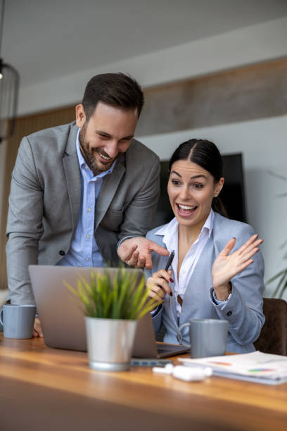 istock Two business people using laptop and discussing about new project at office 1469684364