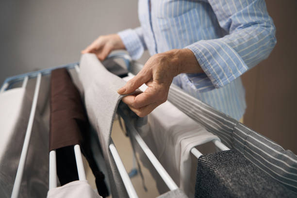 istock Old woman evenly hangs out laundry after washing 1469684681