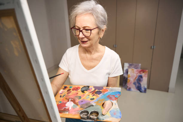 istock Pensioner holds a palette for drawing in her hands 1469684684