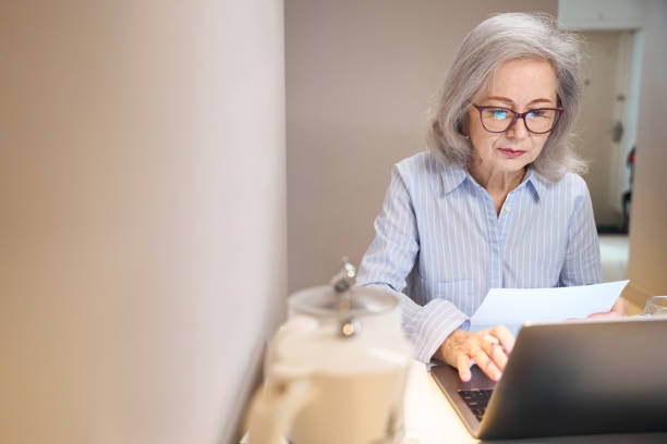 istock Lady with glasses is located with laptop at kitchen table 1469684704