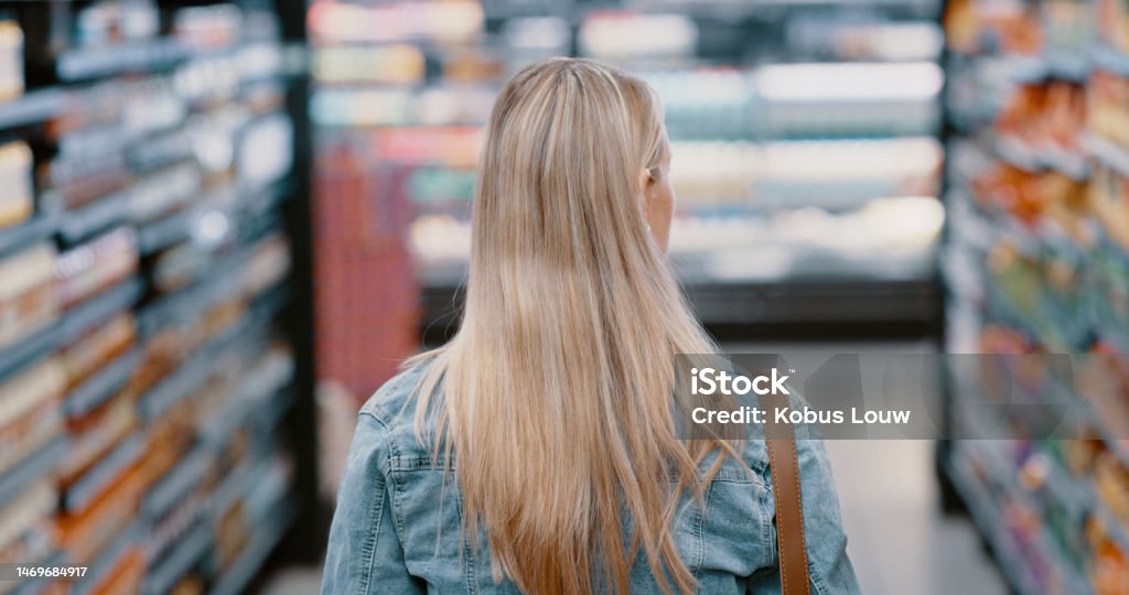 Walking woman, back or aisle grocery shopping for ingredients, cooking product or healthy food in retail sales store. Behind, customer or consumer in supermarket for mall promotion or groceries deal 35-39 Years Stock Photo