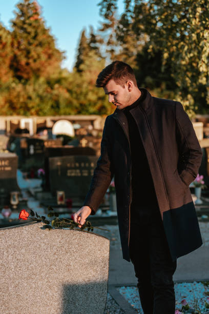 istock Man Laying Flowers On Grave 1469689667