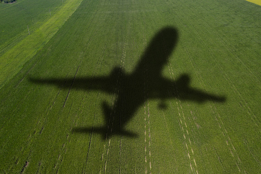 Shadow of the plane on the agricultural field. Concept of decarbonization and biofuel