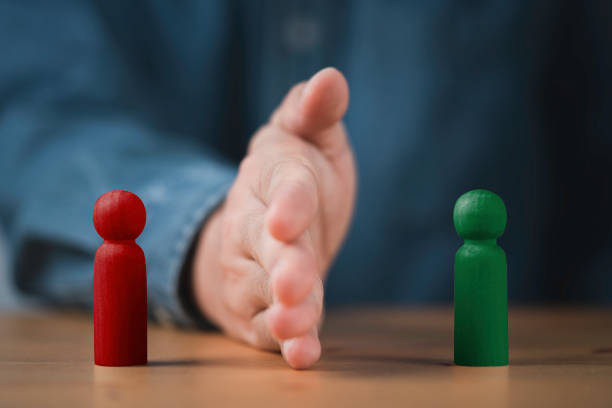 istock Palm hand blocking and divide between red and green wooden figure for resolving conflict and mediate management concept. 1469697594