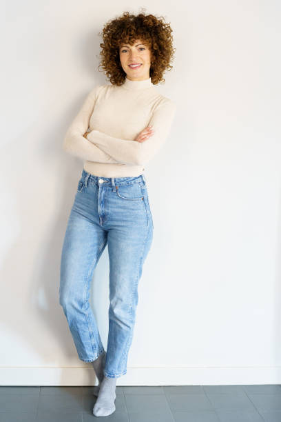 istock Confident woman standing against white wall crossing arms 1469699322
