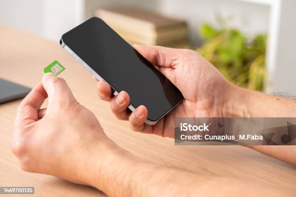 Hand Inserting Sim And Sd Card On Smart Phone Stock Photo - Download Image Now - SIM Card, Smart Phone, Computer Chip