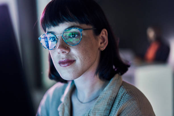 viso della donna d'affari, computer e codifica ux del giovane dipendente con luce blu e occhiali. codice digitale, intelligenza artificiale hacker e lettura di una lavoratrice di notte che pianifica con dati di sicurezza informatica online - dashboard supporto visivo foto e immagini stock