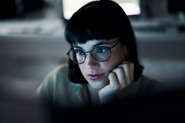 istock Business woman, computer coding and web design employee face with blue light and glasses. Digital code, hacker ai and reading of a female worker at night planning with online cybersecurity data 1469706457