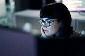 Business woman, computer seo and web design of young worker thinking with blue light and glasses. Digital code, female face and reading of a employee at night planning with online ux and media data