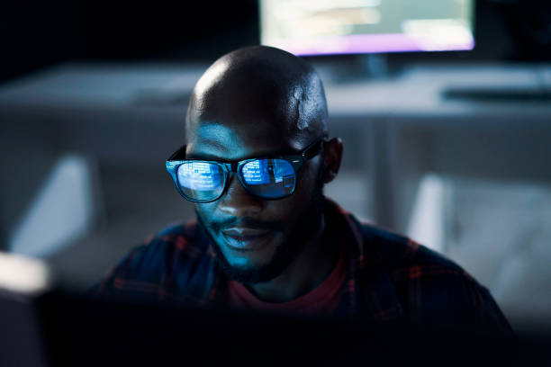 Programmer, black man and code reflection in glasses, cyber security and hacking in workplace. African American male employee, coder or IT specialist with eyewear, focus and programming in office stock photo