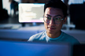 Computer coding, programming and asian man in cybersecurity, software development and html script. Night person from china with information technology career, database code and monitor network safety
