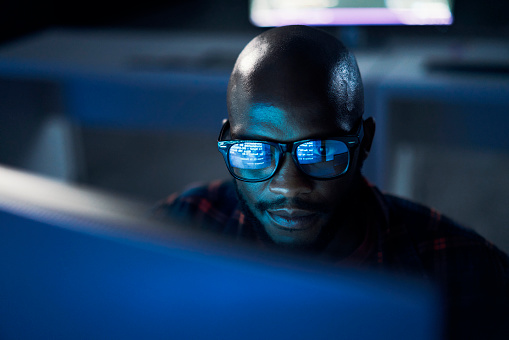 Cyber security, black man and code reflection in eyewear, hacking and software update in office. African American male employee, programmer or IT specialist with glasses, focus and cloud computing