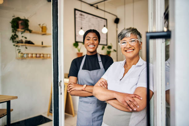coffee shop, senior woman manager portrait with barista feeling happy about shop success. female server, waitress and small business owner together proud of cafe and bakery growth with a smile - family business stockfoto's en -beelden