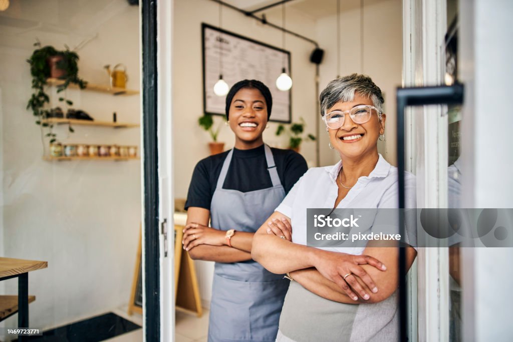 Coffee shop, senior woman manager portrait with barista feeling happy about shop success. Female server, waitress and small business owner together proud of cafe and bakery growth with a smile Small Business Stock Photo