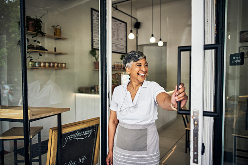 Small business, woman and coffee shop front door with pride for startup, cafe or restaurant. Entrepreneur person or waitress happy for service, management and to welcome for hospitality at store