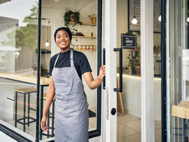 olhando, abrindo e mulher negra na porta de um café para negócios, acolhimento e hospitalidade. entrada, serviço e servidor africano em um café para abrir o restaurante, loja ou lanchonete pela manhã - welcome sign greeting door open - fotografias e filmes do acervo