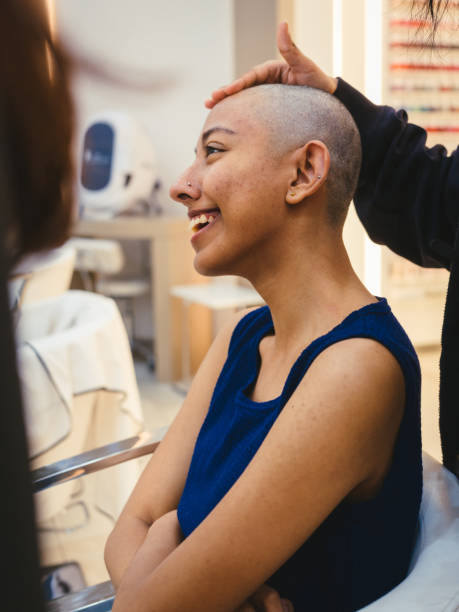 Girl donating hair to a cancer charity foundation Young woman getting her head shaved for hair donation to a cancer charity self sacrifice stock pictures, royalty-free photos & images