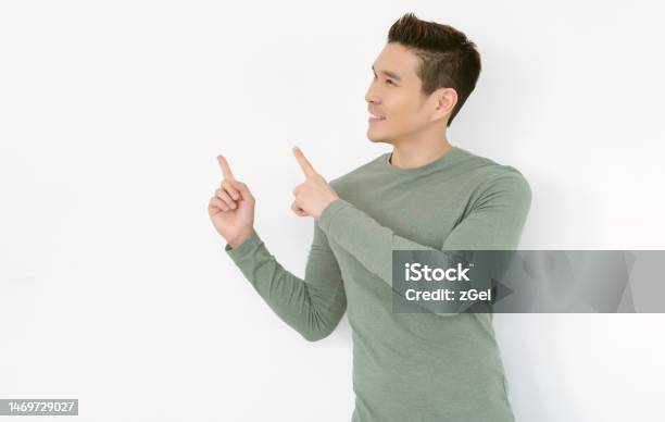 Positive Handsome Young Asian Man Wearing Casual Clothes Pointing Two Fingers Empty Space Isolated On White Background Great Idea Cool Offer Stock Photo - Download Image Now