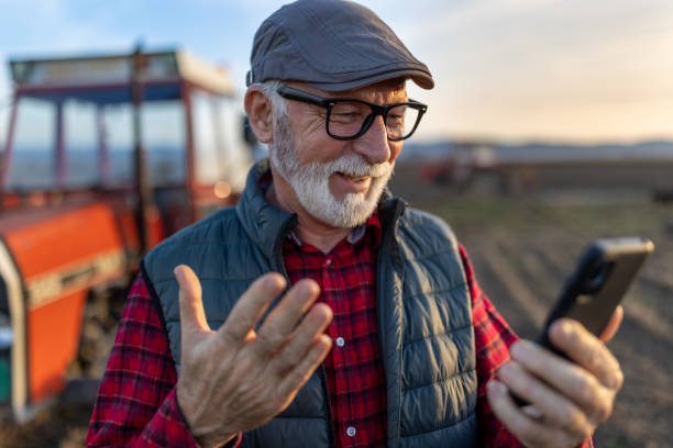istock Senior farmer with mobile phone in field 1469731033