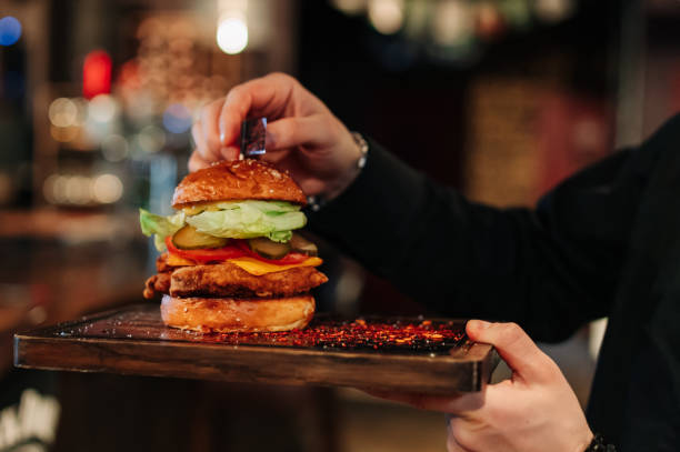 istock Men's waiter hands hold a tray with a cheeseburger in pub 1469731160