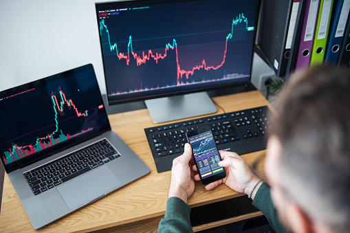 Close-up shot of unrecognizable man trading with crypto at home.