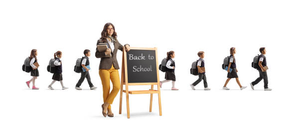 istock Teacher with blackboard and schoolchildren walking behind 1469731650