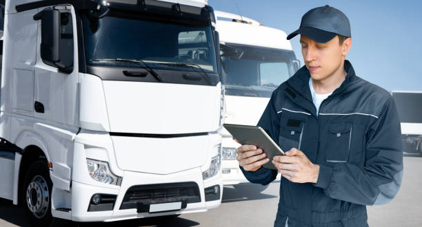 istock Manager with a digital tablet on the background of trucks. 1469733039