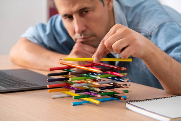 bored lazy worker with his hands wasting time playing with pens Close-up of the hand of a bored lazy worker with his hands wasting time playing with pens sitting at a desk in the office dillydally stock pictures, royalty-free photos & images