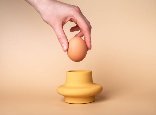 istock Hand taking natural healthy chicken egg from holder, cup for breakfast. Monochrome composition of nutrition 1469735850