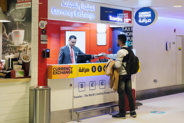 Travelex currency exchange office at the Abu Dhabi airport terminal Travelex currency exchange office at the Abu Dhabi airport terminal. A man with a backpack submits a passport for cash exchange. Abu Dhabi, UAE - 22.01.2023 cash in transit vehicle stock pictures, royalty-free photos & images