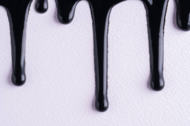 istock Black liquid drops of paint color flow down on white canvas. Abstract art. Black paint dripping on the white wall with copy space. 1469738551