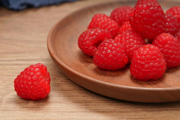 istock A plate of raspberries on a wooden table 1469740237