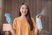 close up young asian female woman cleaning the house with sanitising spray splash or  with a disinfectant spray bottle water fog into the room at home during the day ,Woman cleaning home or apartment
