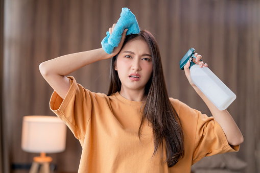 asia woman feeling problem headache about house cleaning work hand holding cleaning equipment