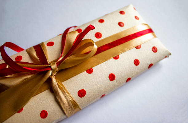 明るい背景に弓で飾られた平らな幻想的な包装された贈り物。コピー用スペース付きの赤と黄色のリボンを使ったギフト包装の上面図 - gift greeting card birthday card red ストックフォトと画像