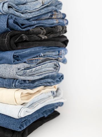 Denim pants stack on white background. Shopping concept