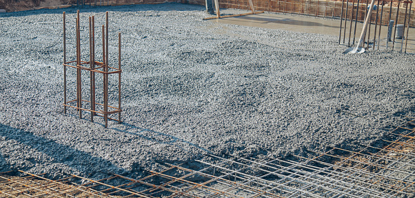 Base floor reinforcement bar mesh with poured fresh concrete on a new construction building