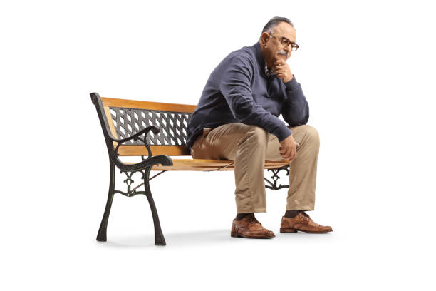 Pensive mature man sitting on a bench and thinking isolated on white background