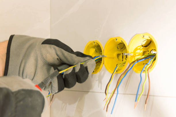 istock Electrician hands mounting electric wall receptacle fitting into place 1469745721