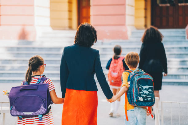istock Mother leads her children to school 1469751896