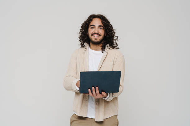 istock Cheerful hispanic man working on laptop isolated over white wall 1469753391
