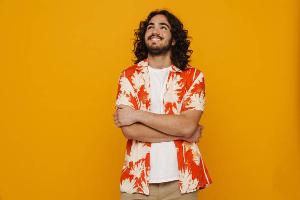 istock Smiling hispanic man standing with arms folded isolated over yellow wall 1469753447